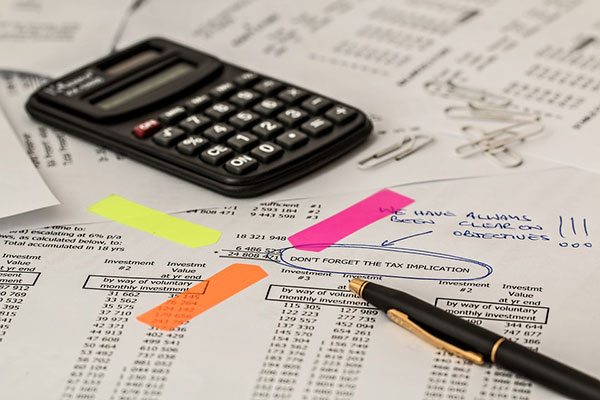 calculator and pen laying on financial documents